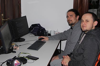 Azubi Robert beim Pairprogramming mit einem Senior-Entwickler am Schreibtisch