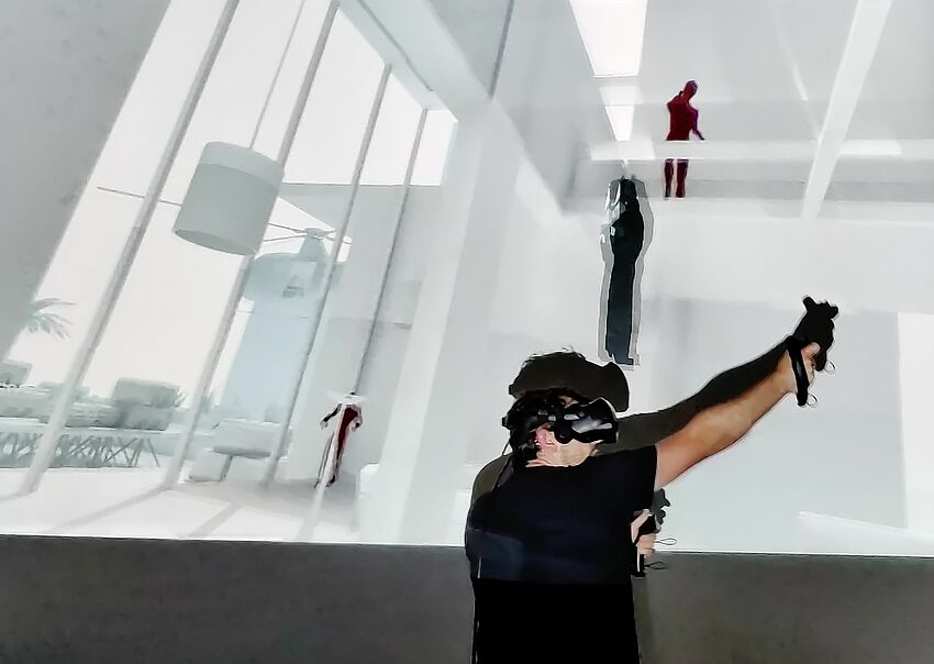 Mitarbeiter vor der Leinwand bei einem Spiel mit VR Brille 